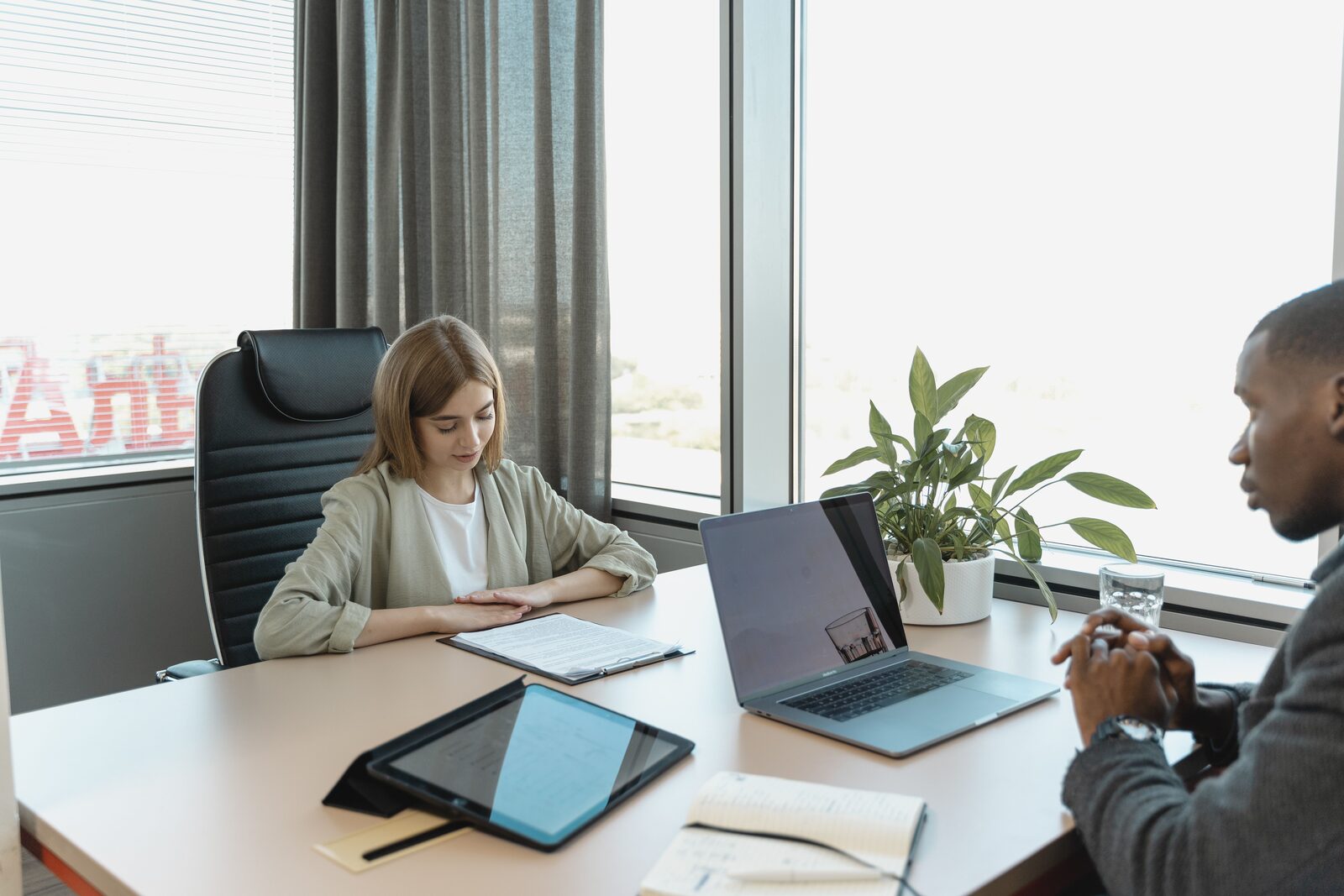 To personer i en jobsamtale med bærbar computer og tablet på bordet